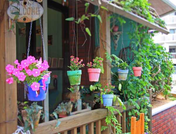 Hanging painted pots on a spring front porch 
